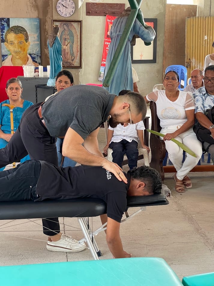 Dr. Kevin Ernesto realizando un ajuste quiropráctico durante misión en iglesia y comunidad